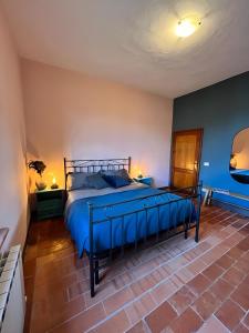 ein Schlafzimmer mit einem großen Bett mit blauer Bettwäsche in der Unterkunft La casa terra dei sogni in Castiglione del Lago