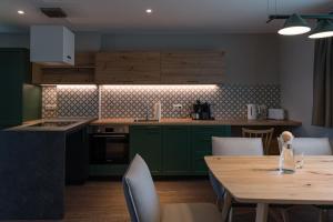 une cuisine avec des placards verts et une table en bois dans l'établissement Alm-Chalet Premium 2, à Clausthal-Zellerfeld