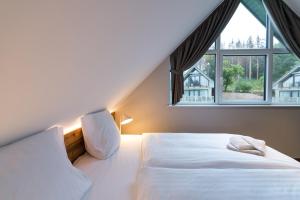 - une chambre avec un lit et une grande fenêtre dans l'établissement Alm-Chalet Premium 2, à Clausthal-Zellerfeld