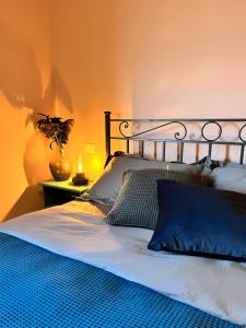 1 dormitorio con 1 cama con almohadas azules en La casa terra dei sogni, en Castiglione del Lago