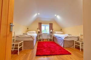 a room with two beds and a red rug at Finest Retreats - The Old Granary in Barton Stacey