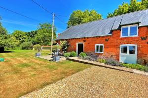 a red brick house with a yard in front of it at Finest Retreats - The Old Granary in Barton Stacey