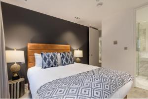 a bedroom with a large bed and two lamps at Synergy The Strand in London