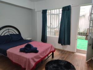 een slaapkamer met een bed met een roze deken bij Departamento 101 La Santisima in Mexico-Stad