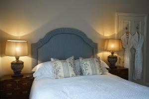 ein Schlafzimmer mit einem Bett mit Kissen und zwei Lampen in der Unterkunft Maplewood Cottage, Wynyard Hall 
