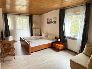 a bedroom with a bed and two windows at Waldhotel Porta Westfalica in Porta Westfalica