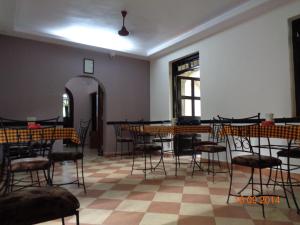uma sala com mesas e cadeiras e um piso xadrez em Palolem Guest House em Palolem
