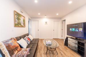 a living room with a couch and a flat screen tv at Southgate 5 Bedroom Vacation Home with Double Garage in Edmonton +37 photos