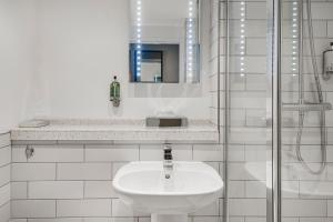 ein weißes Badezimmer mit einem Waschbecken und einem Spiegel in der Unterkunft The Red Lion by Innkeeper's Collection in Portsmouth