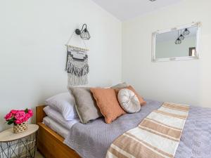 sypialnia z łóżkiem z poduszkami i lustrem w obiekcie VisitZakopane - Emperor Apartment w Zakopanem