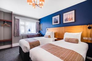 two beds in a hotel room with blue walls at The Red Lion by Innkeeper's Collection in Portsmouth