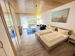 ein Schlafzimmer mit einem Bett und ein Wohnzimmer in der Unterkunft Waldhotel Porta Westfalica in Porta Westfalica