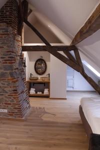 a room with a bed and a brick wall at Maison de vacances Le Vieux Marronnier in Dinant