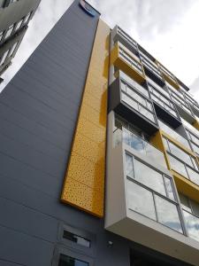 a building with a yellow and black facade at Ulivin Apartaestudios Manizales in Manizales