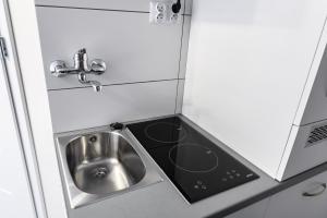 a small kitchen with a sink and a microwave at Magnetic apartment Nowogrodzka B in Warsaw