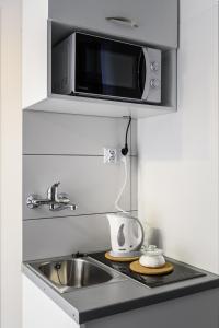 a kitchen with a sink and a microwave at Magnetic apartment Nowogrodzka B in Warsaw
