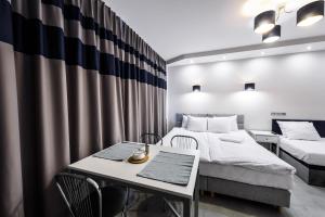 a bedroom with two beds and a table and chairs at Magnetic apartment Nowogrodzka B in Warsaw
