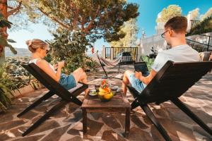a man and woman sitting in chairs with their laptops at Villa Bella Salmagi in Capitana