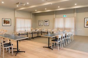 una sala de conferencias con mesas y sillas. en Ballarat Colonial Motor Inn, en Ballarat