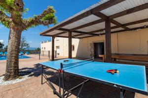 a ping pong table in a patio with a tree at Can Bugantó amplia casa con piscina y jardín in Llambillas
