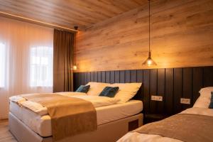 two beds in a room with wooden walls at Hillside No. 18 in Loučná pod Klínovcem