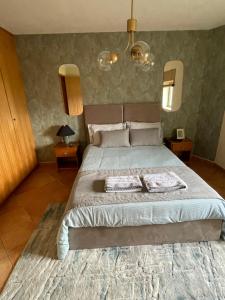 una camera da letto con un grande letto con due asciugamani di Refúgio da Légua a Marco de Canaveses