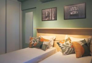 1 dormitorio con 2 camas y 2 cuadros en la pared en XBase Studio Parque Augusta-Higienópolis Mackenzie en São Paulo