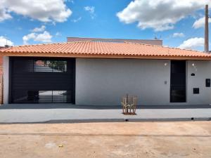 uma casa com uma cadeira em frente em Recanto Fernandes & Melo em Olímpia