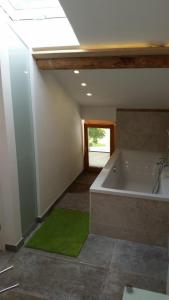 ein Badezimmer mit einer Badewanne und einem grünen Teppich in der Unterkunft Haus Malerwinkl in Ramsau bei Berchtesgaden