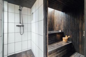 a bathroom with a shower and a bench in a room at Stylish 2 Bedroom Flat with a Private Sauna in Finchley
