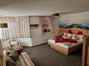 ein Schlafzimmer mit einem Bett und einem Sofa in einem Zimmer in der Unterkunft Haus Haas in Lermoos