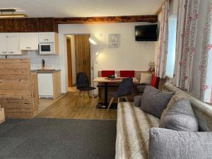 a living room with a couch and a table and a kitchen at Haus Haas in Lermoos