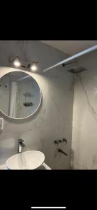 a white bathroom with a sink and a mirror at Monoambiente con cochera. Excelente ubicación. in Mar del Plata
