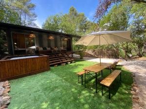 a patio with a table and an umbrella at SUBLIME CHALET*JACUZZI*JARDIN*PLANCHA*CLIM*WIFI* in Meyreuil