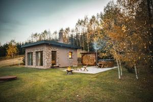 a small stone house in a yard with a grill at Glamping Vyhlídka in Chvaleč