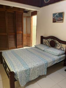 sypialnia z łóżkiem z niebiesko-białym kocem w obiekcie Casas Manatwar`s w mieście San Andrés