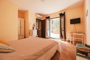 a bedroom with a bed and a television in it at Villa Bella Salmagi in Capitana