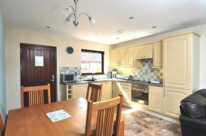 a kitchen with a table and a dining room at Composers at Woodlands in East Ord
