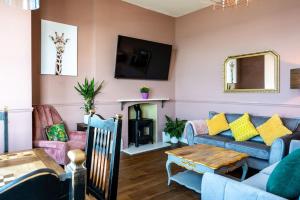 uma sala de estar com um sofá e uma mesa em Stylish Beachfront Apartment, Sweeping Ocean Views and Luxury Touches em Herne Bay