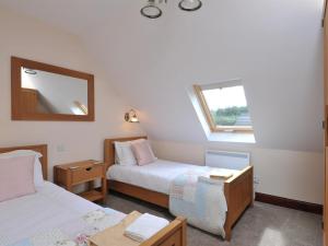 a room with two beds and a mirror and a window at Composers at Woodlands in East Ord
