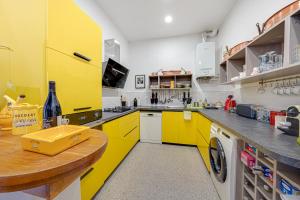 kuchnia z żółtymi szafkami, pralką i suszarką w obiekcie Vue sur le port superbe appartement atypique, logement entier w Marsylii