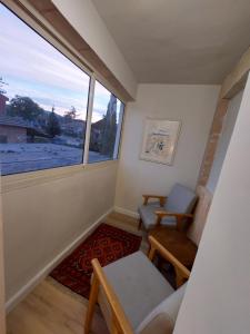 ein kleines Wohnzimmer mit einem Fenster und einem Stuhl in der Unterkunft Lishansky Since 1936 in Metulla