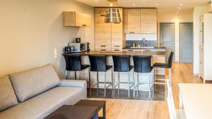 a living room with a couch and a kitchen at Neptune in Cavalaire-sur-Mer