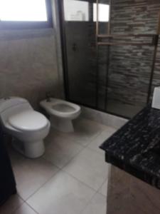 a bathroom with a toilet and a shower and a sink at Departamento vacacional in Guayaquil