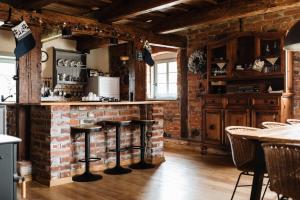 eine Küche mit einer Backsteinwand und 2 Barhockern in der Unterkunft Potasznia 31 in Gądkowice + 17 Fotos