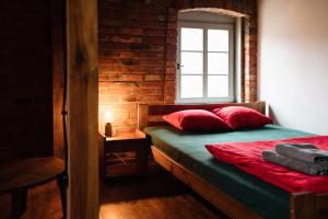 ein Schlafzimmer mit einem Bett mit roten Kissen und einem Fenster in der Unterkunft Potasznia 31 in Gądkowice