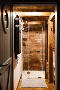 eine Glasdusche im Bad mit Ziegelwand in der Unterkunft Potasznia 31 in Gądkowice
