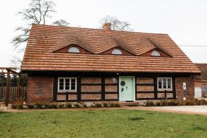 ein Haus mit einem braunen Dach und einer grünen Tür in der Unterkunft Potasznia 31 in Gądkowice