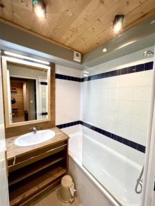 La salle de bains est pourvue d'un lavabo, d'une baignoire et d'un miroir. dans l'établissement VUE PANORAMIQUE & RÉNOVÉ CENTRE STATION 1800 - 2 Chambres - 6 PERS, aux Orres