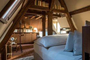Cour des Vosges - Evok Collection في باريس: غرفة نوم بسرير في غرفة بسقوف خشبية